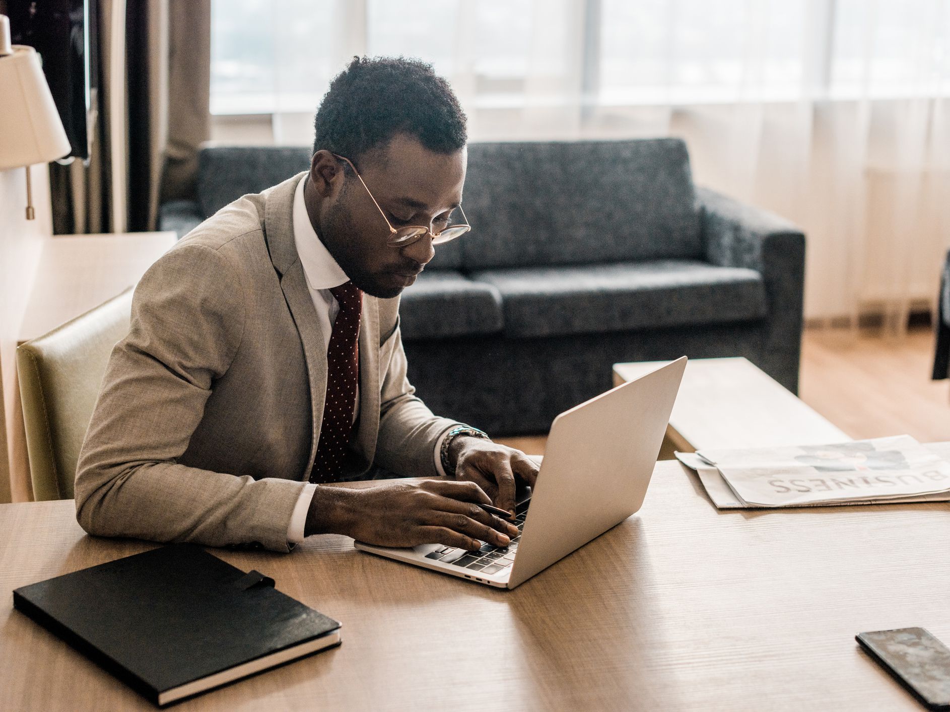 african american businessman working on laptop in hotel room