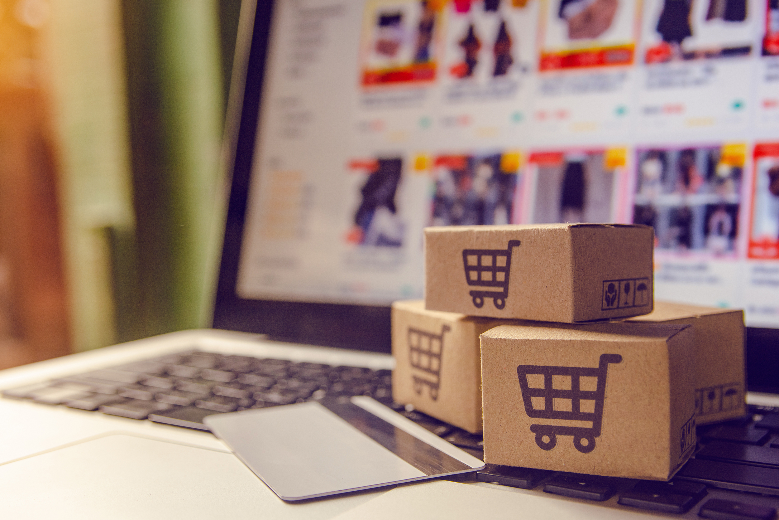 small boxes on a laptop with a credit card to show online shopping