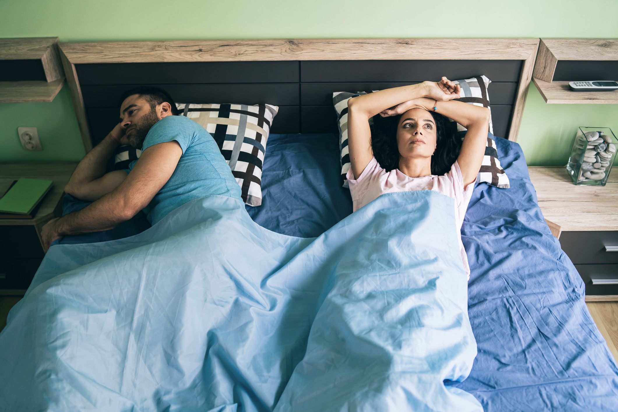 Unhappy couple awake in bed