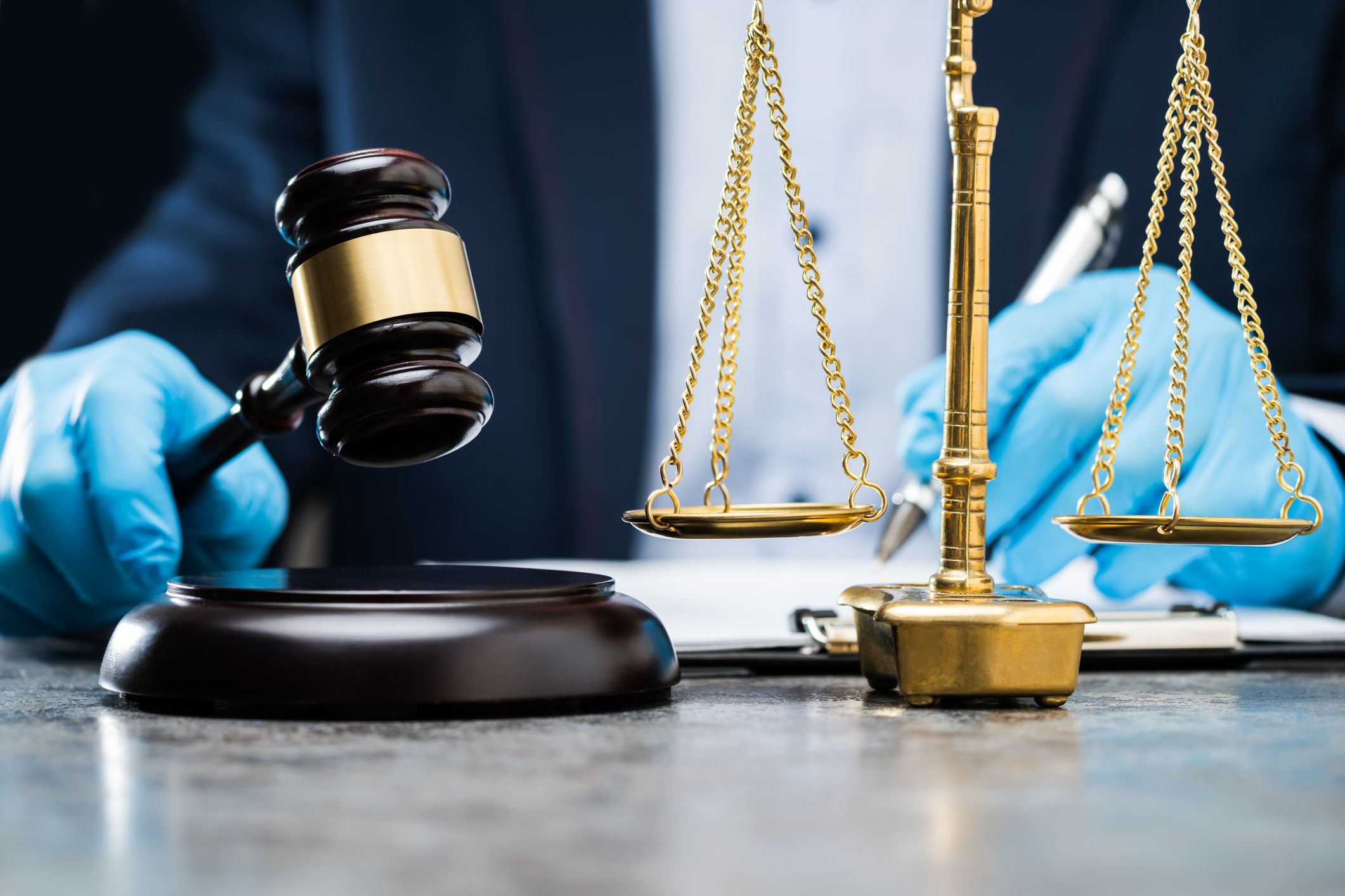 Judge In Gloves To Protect From Coronavirus Writing On Paper