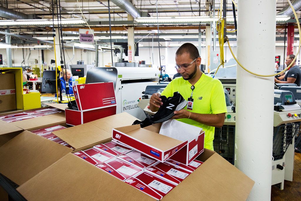 A factory worker at the New Balance shoe factory inspects products
