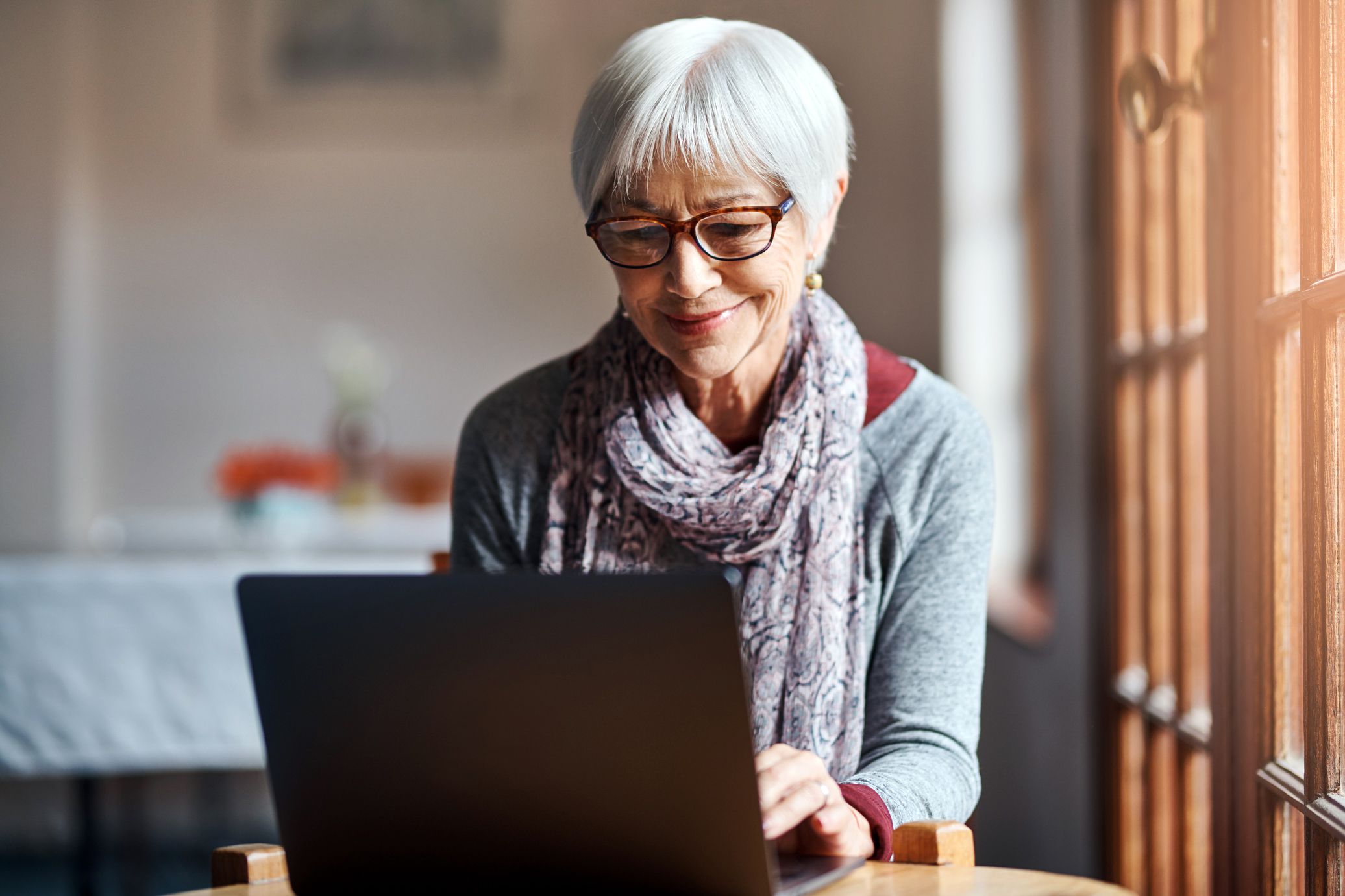 Shot of a senior woman using a laptop in a retirement home