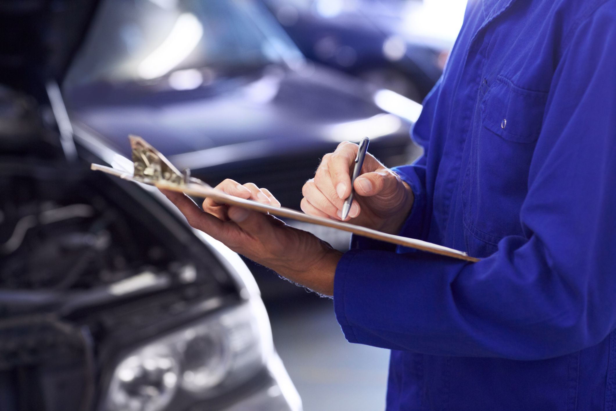 Close up of a car mechanic doing a check list on his clipboard