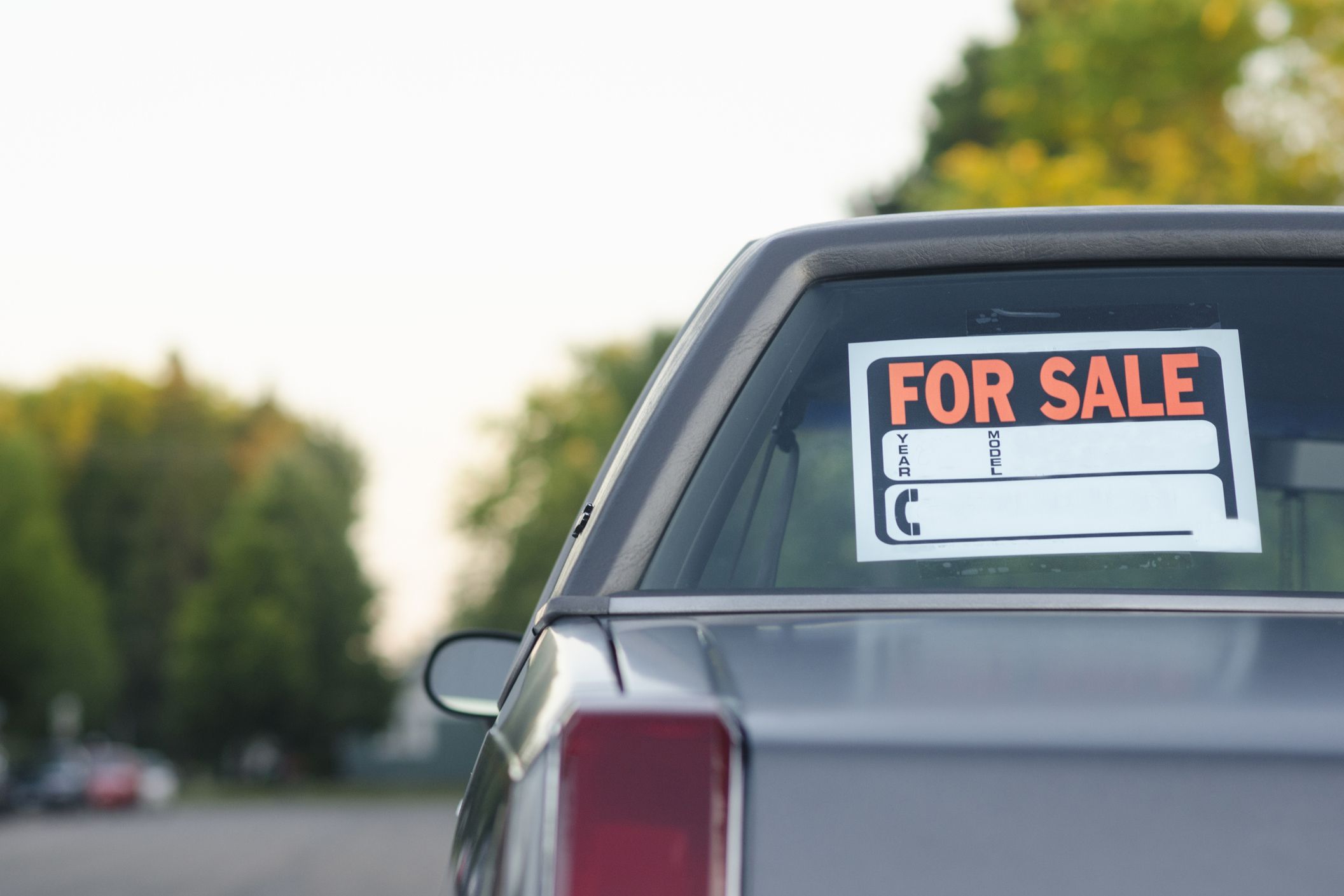 Parked vehicle for sale on a street, with space for own text.