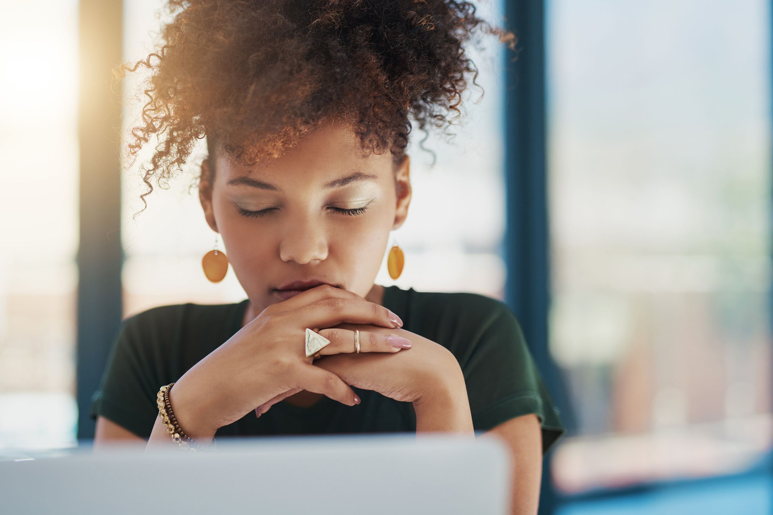 woman with closed eyes at her desk
