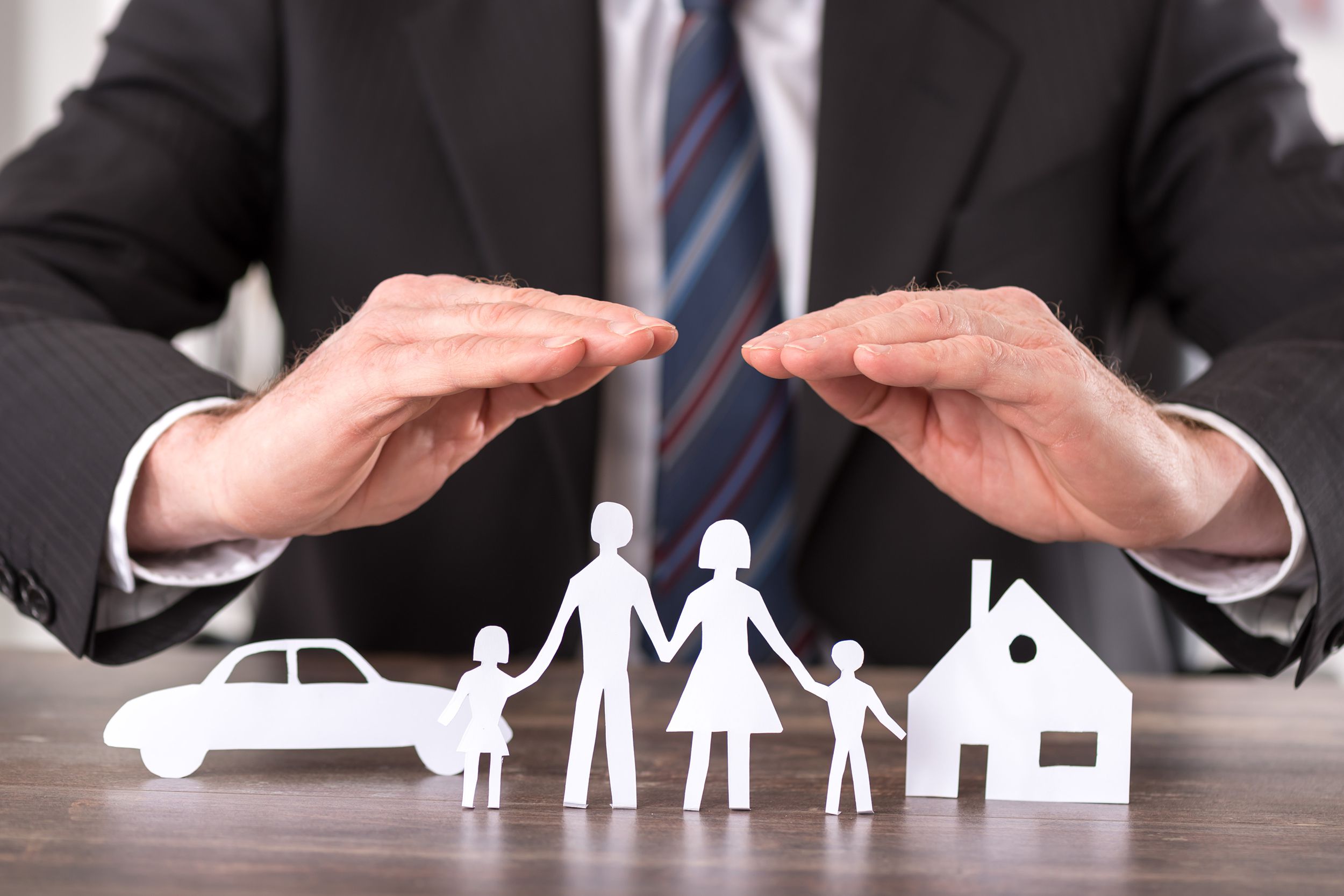 hands cover paper family, car, and home