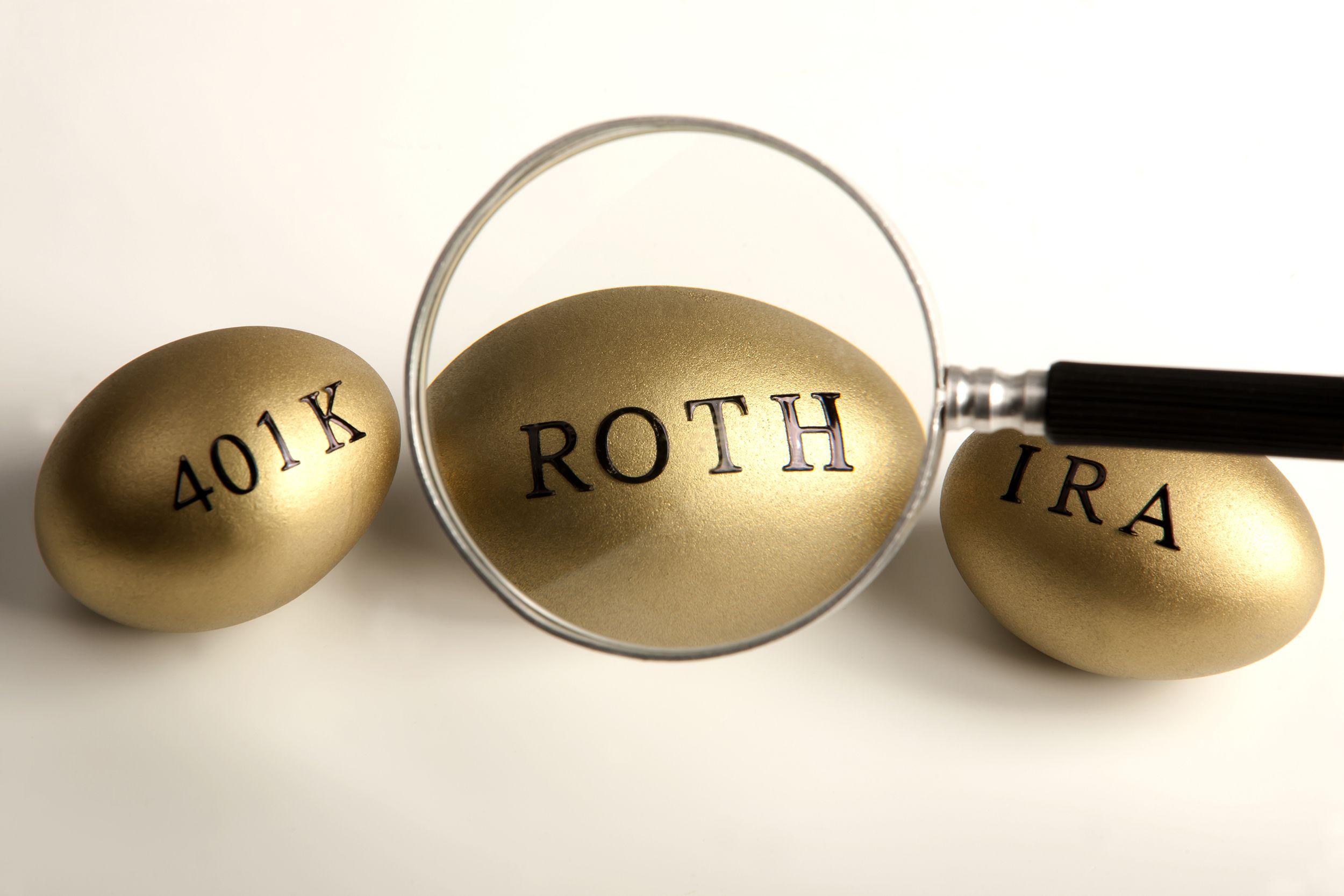 magnifying glass over ROTH egg, in the middle of 401k and IRA eggs