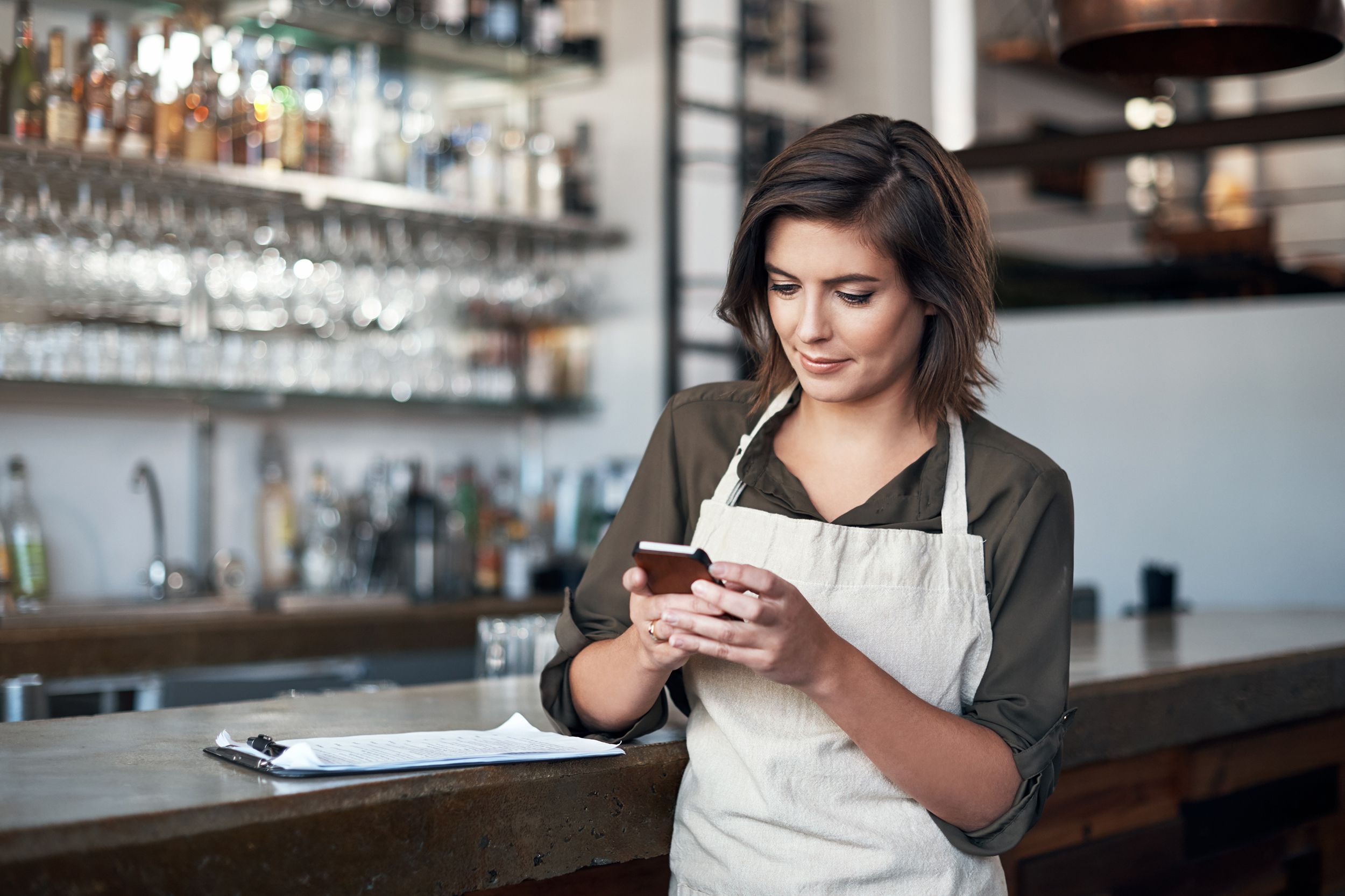woman on phone working at bar