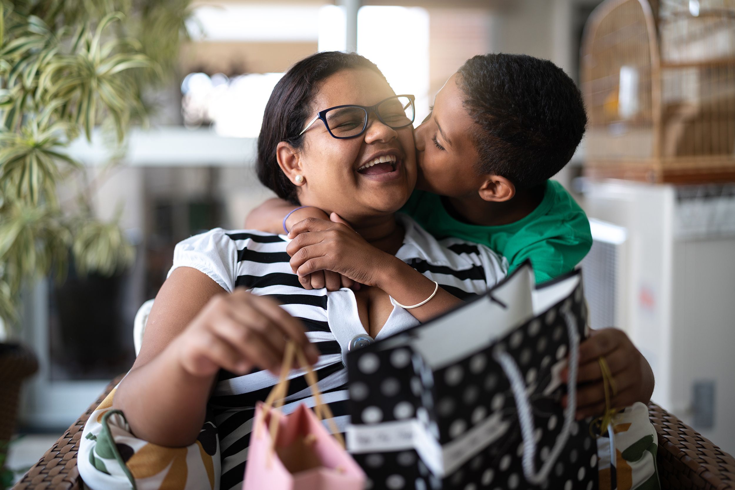 Boy hugging his mom and giving her gifts