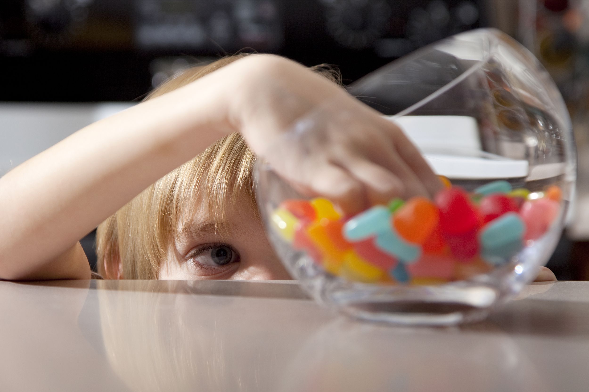 boy taking jelly beans from bowl