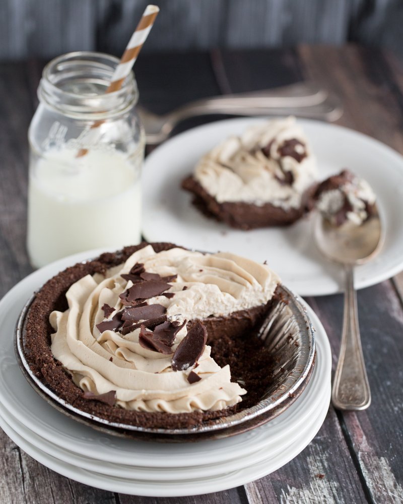 fresh chocolate cream pie with one piece removed and on a plate