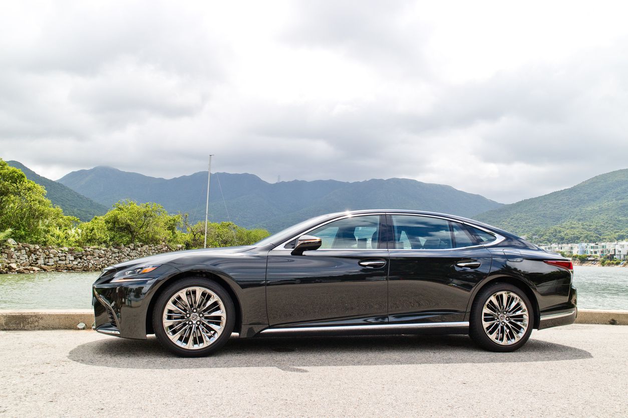 Black or navy blue Lexus LS500 2018 parked in front of a body of water