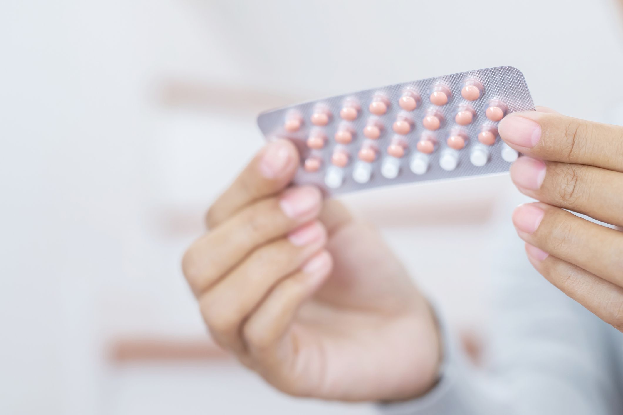Woman hands opening birth control pills in hand. Eating Contraceptive Pill.