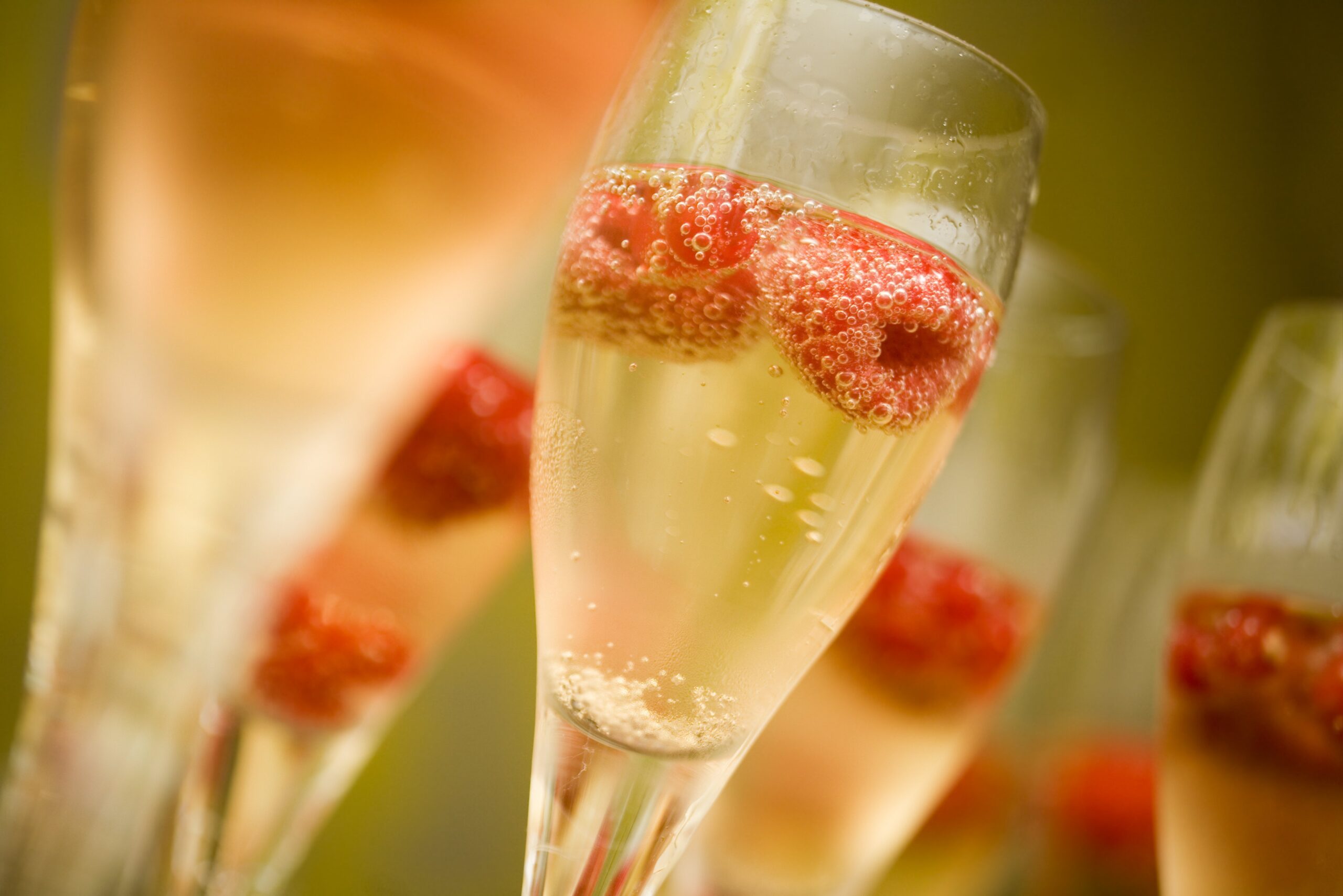 champagne flutes with champagne and raspberries