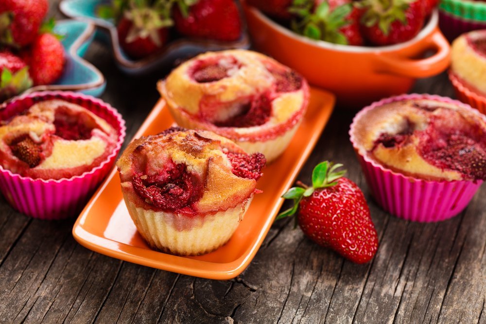 fresh baked strawberry muffins accompanied by fresh strawberries