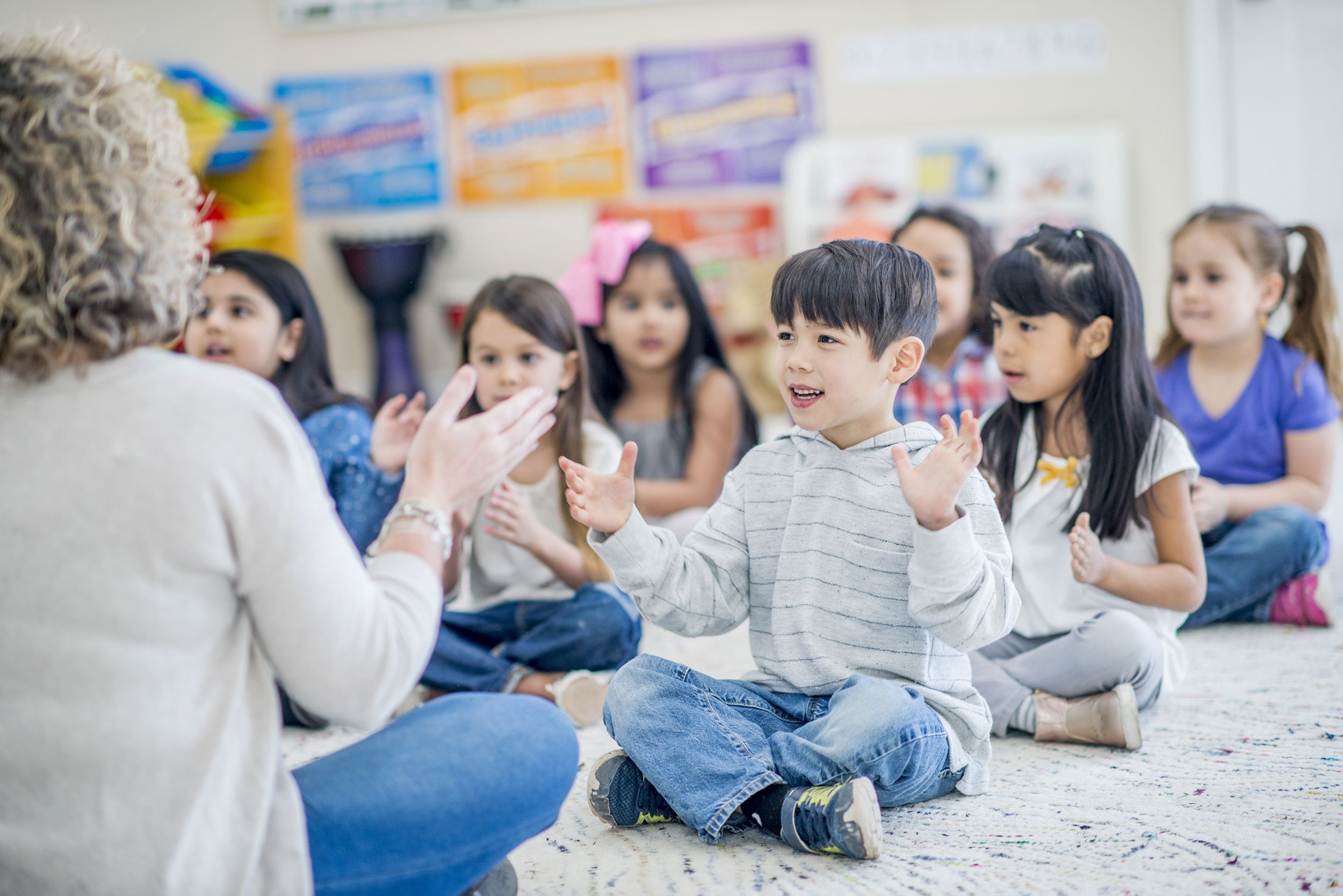 preschool teacher teaching kids to clap to song