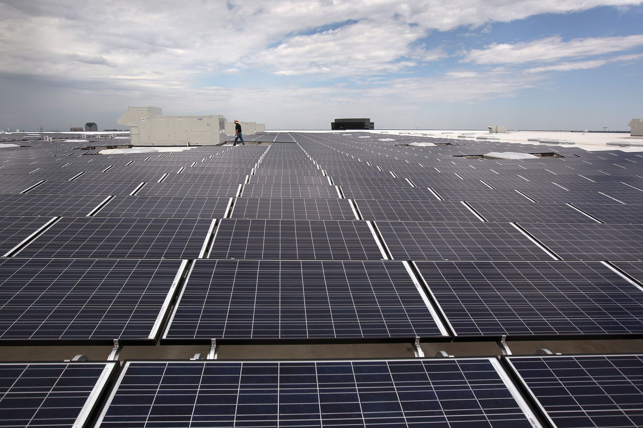 A worker walks amid a field of solar panels atop the new Ikea home furnishings store on July 26, 2011 in Centennial, Colorado