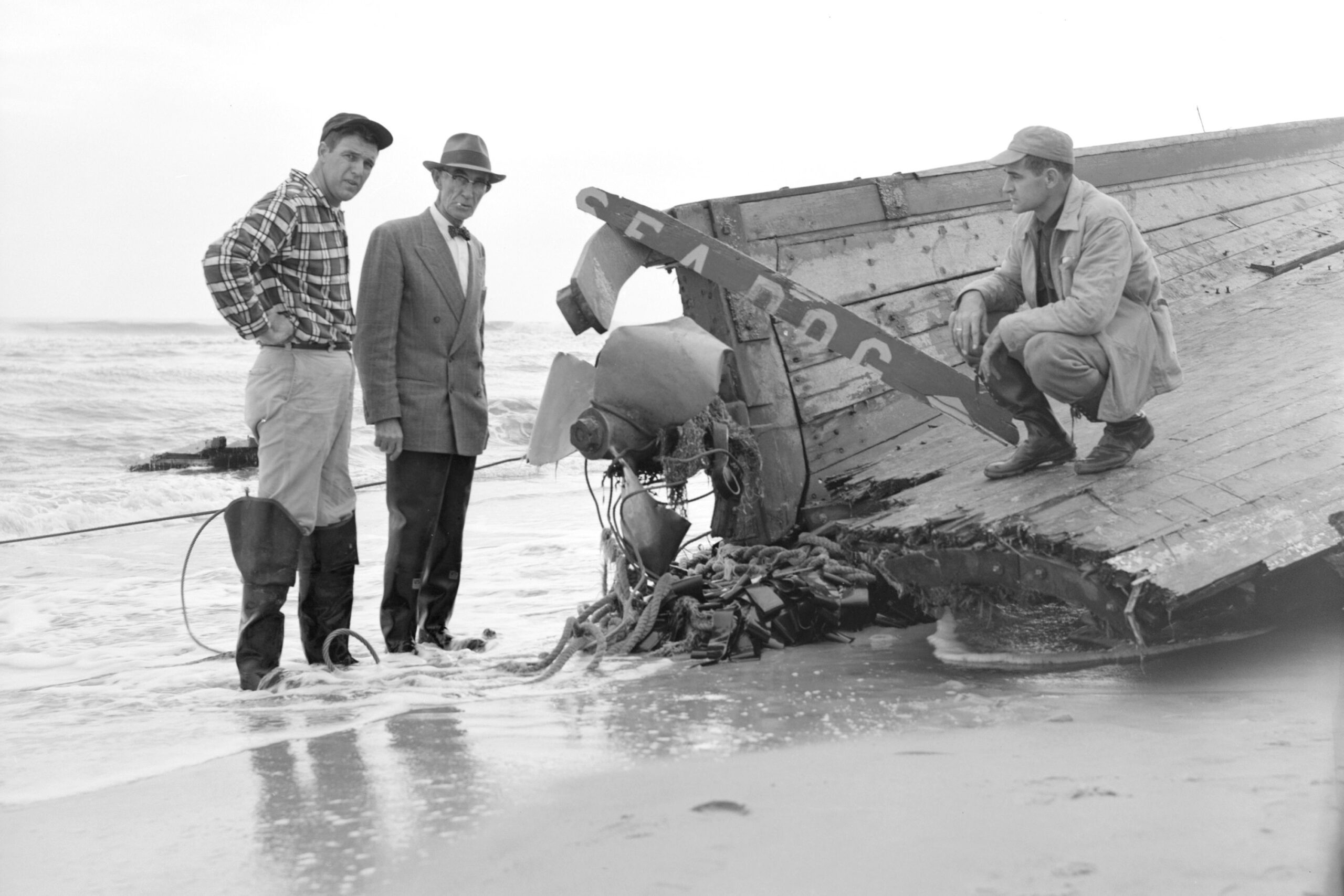 Owner of Sea Dog, and sons, at stern of wreck, Salvo, North Carolina, 1957
