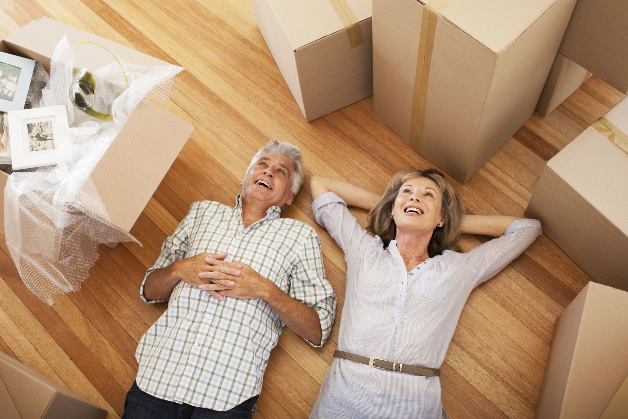Happy couple laying on floor of new house