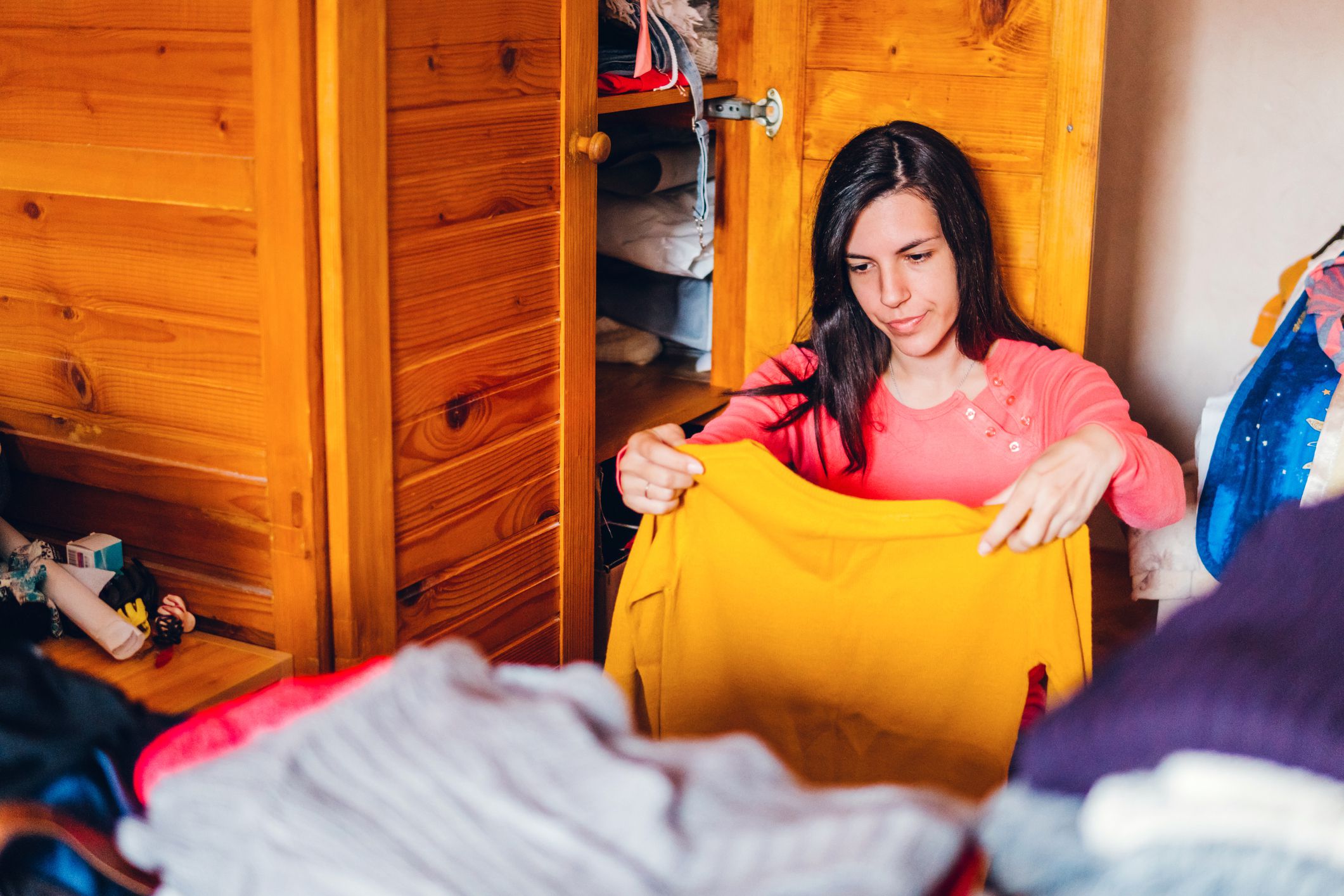 Young stressed woman is sorting out wardrobe