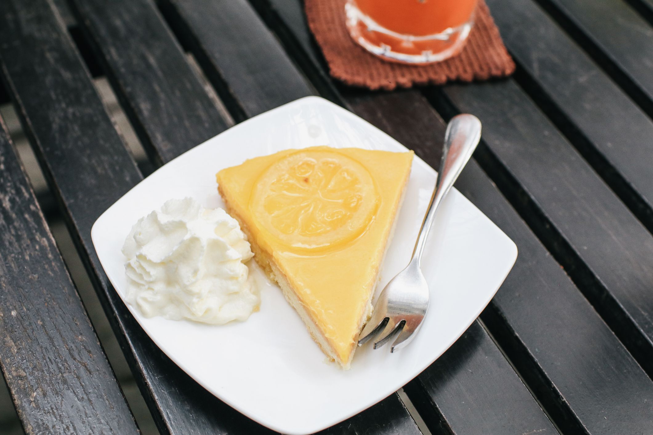 Healthy dessert plate with delicious citrus cake, fork on table wooden table.A baking dish with a custard lemon filling decorated.Tasty fruit dessert. Vertical, selective focus.