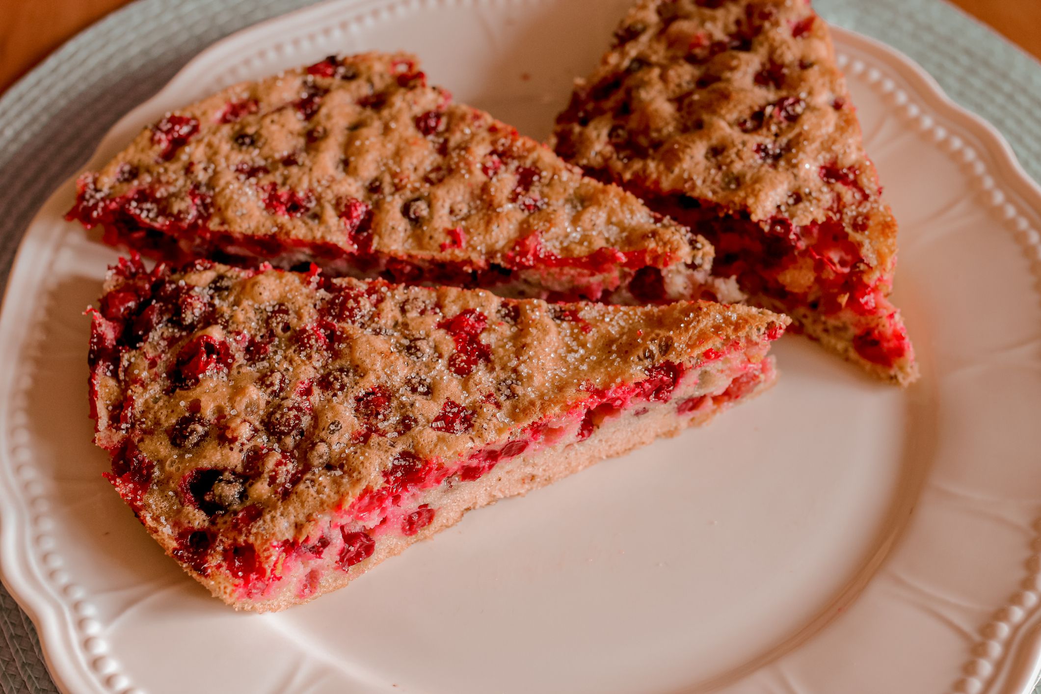 Three pieces of cranberry pie on a white plate with green towel. Delicious homemade dessert for lunch or breakfast.