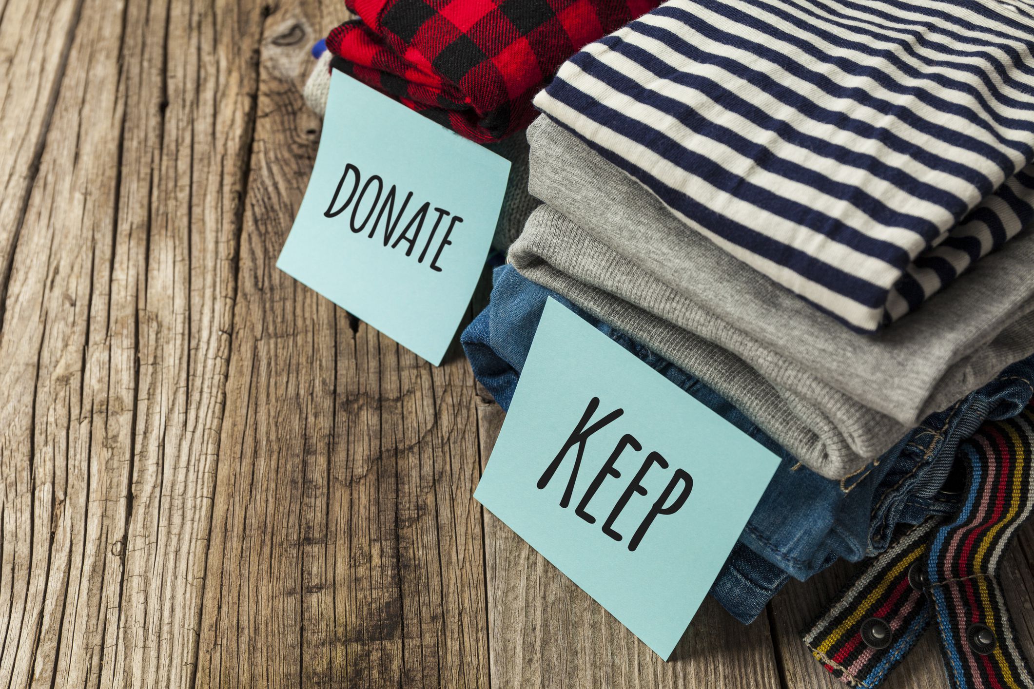 Stack of old clothes to discard (declutter) or keep. Recycle clothes, eco cotton.