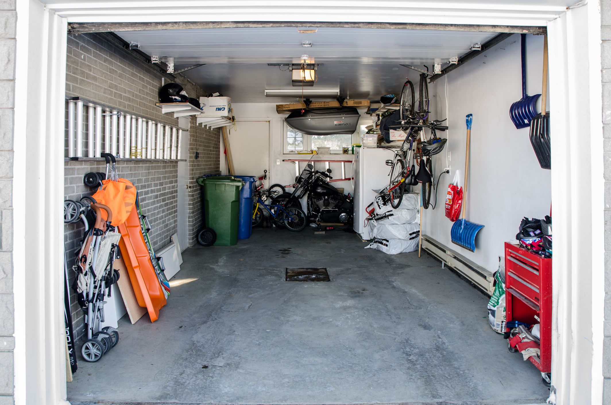 The interior of a car residential garage without the car where we see all the stuff that can be found in a garage.