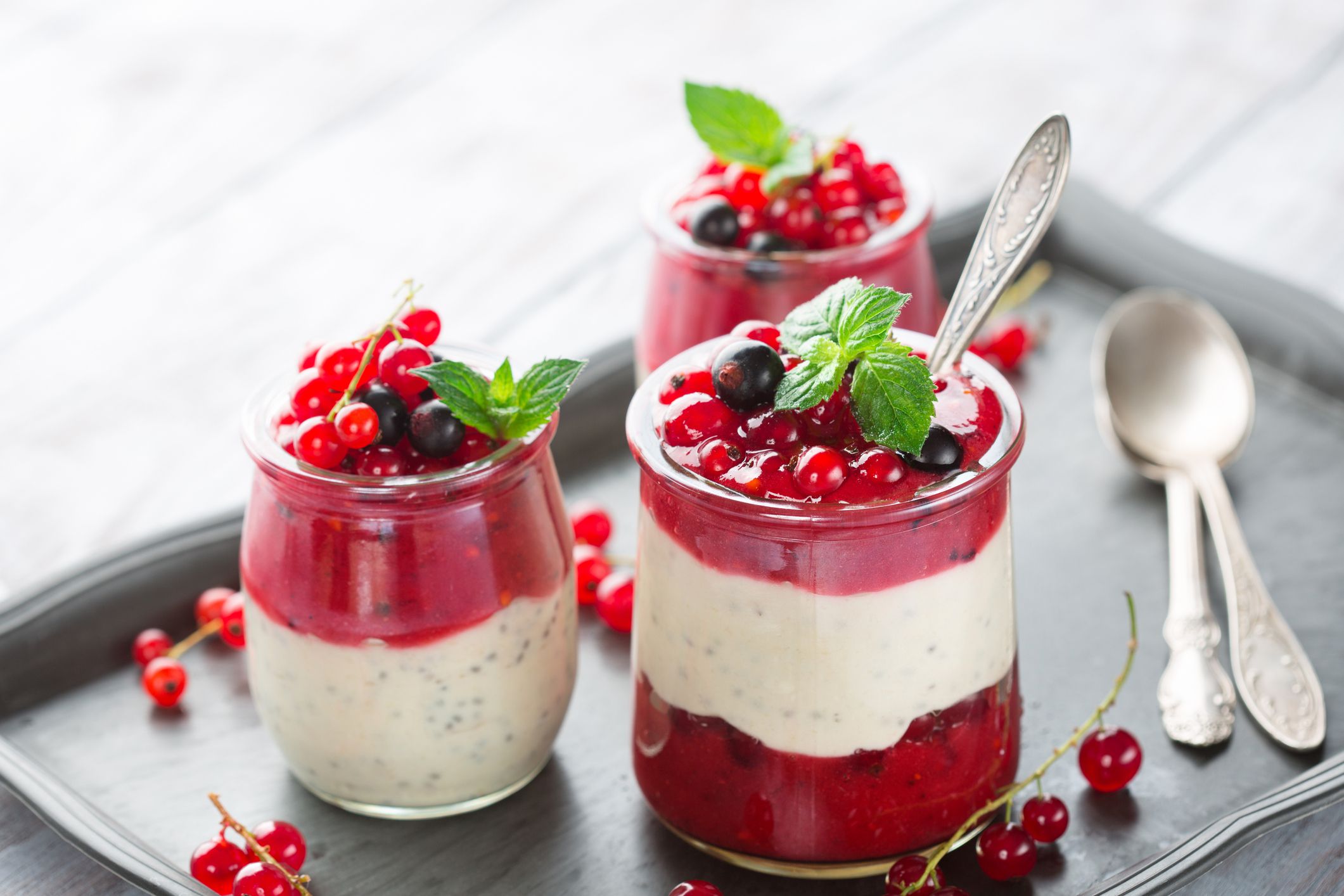 Layered berry and chia seeds smoothies in jar for breakfast on white rustic wooden background, selective focus