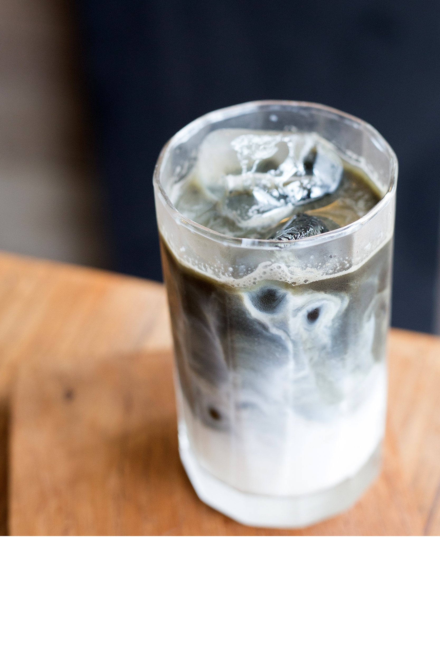 Charcoal coffee with milk in a glass