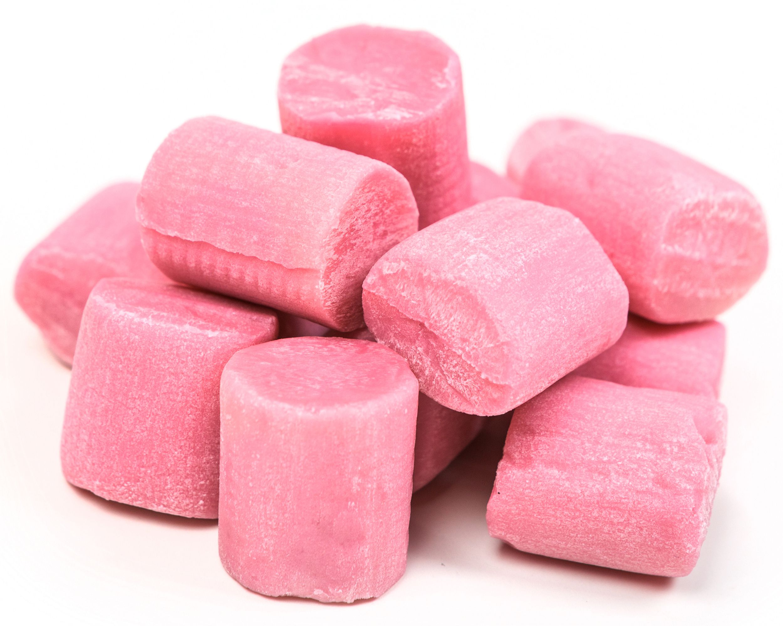 Many pieces of unwrapped pink gum in a pile on a white background