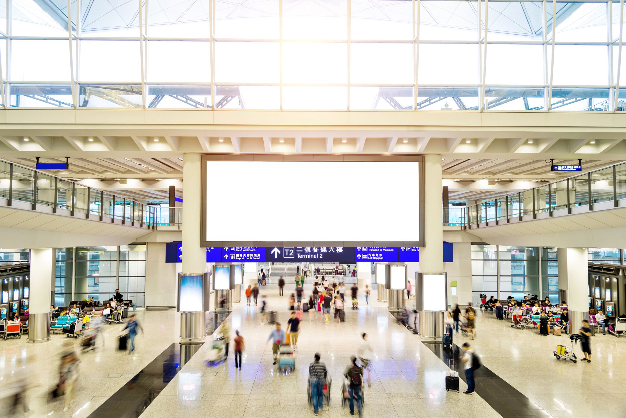 Blurred people and blank billboard in airport.