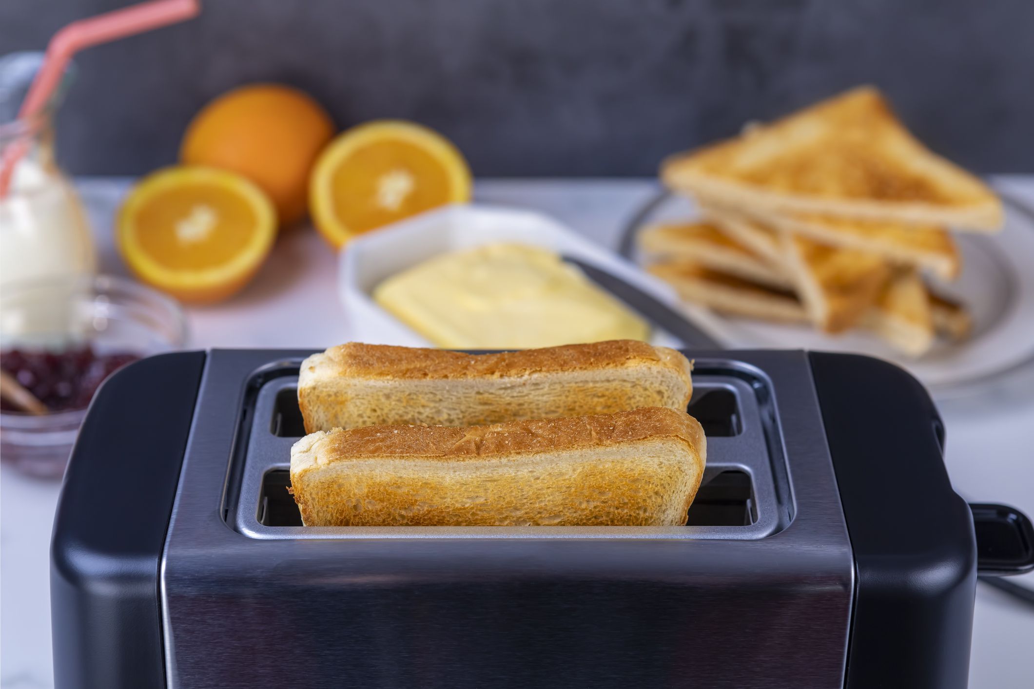 Slices of great toast coming out of the toaster. Healthy breakfast food and heating technology concept. Focus on slice of great.