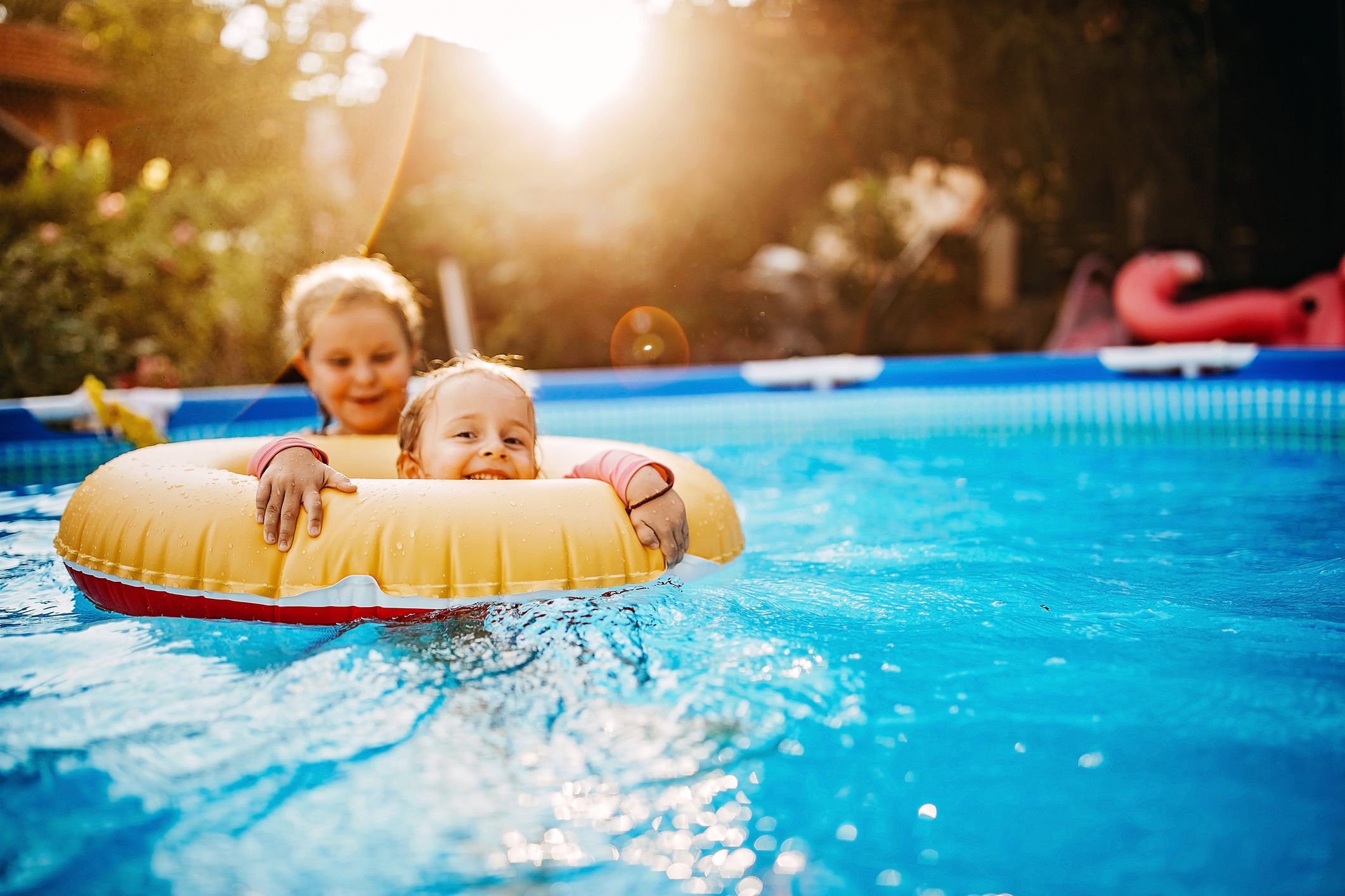 Kids playing in pool, hot summer day in back yard