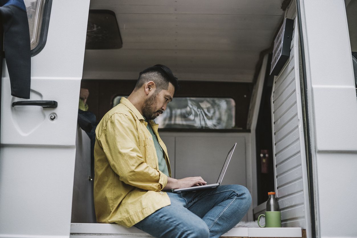 Man Using Laptop in RV Camper Van