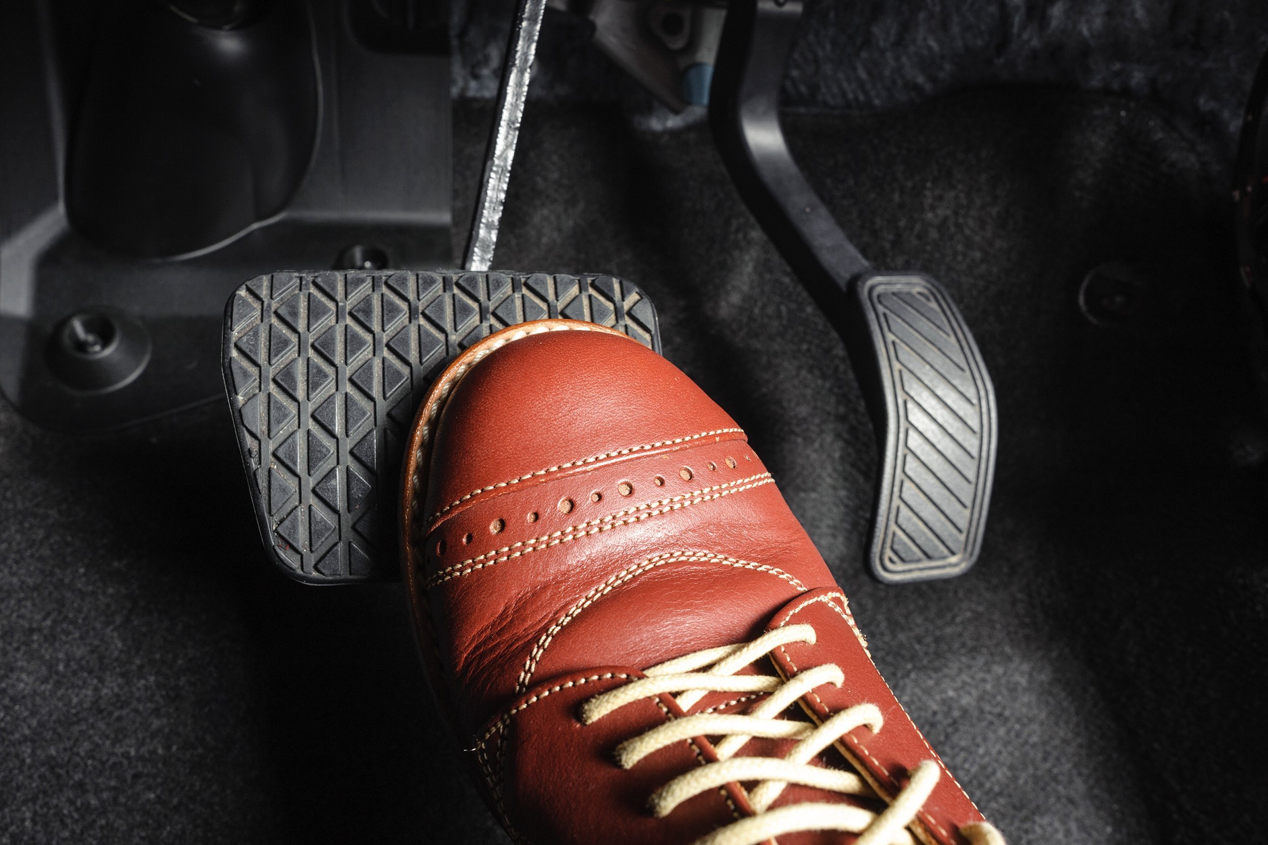 foot pressing the brake pedal of a car