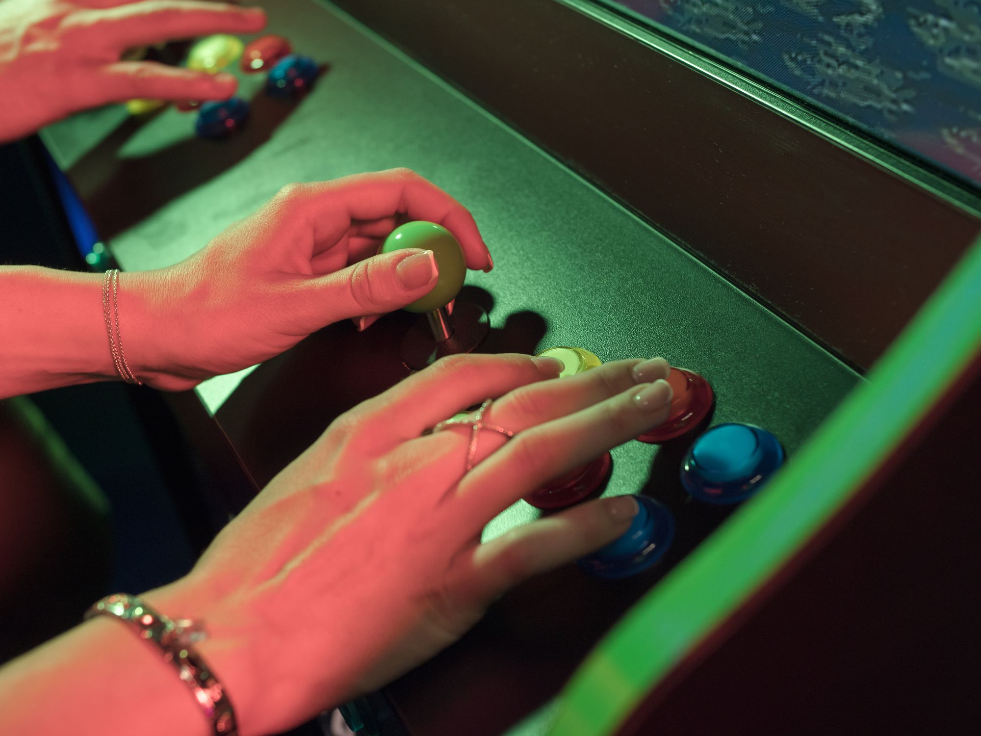 Two adults playing game in video arcade