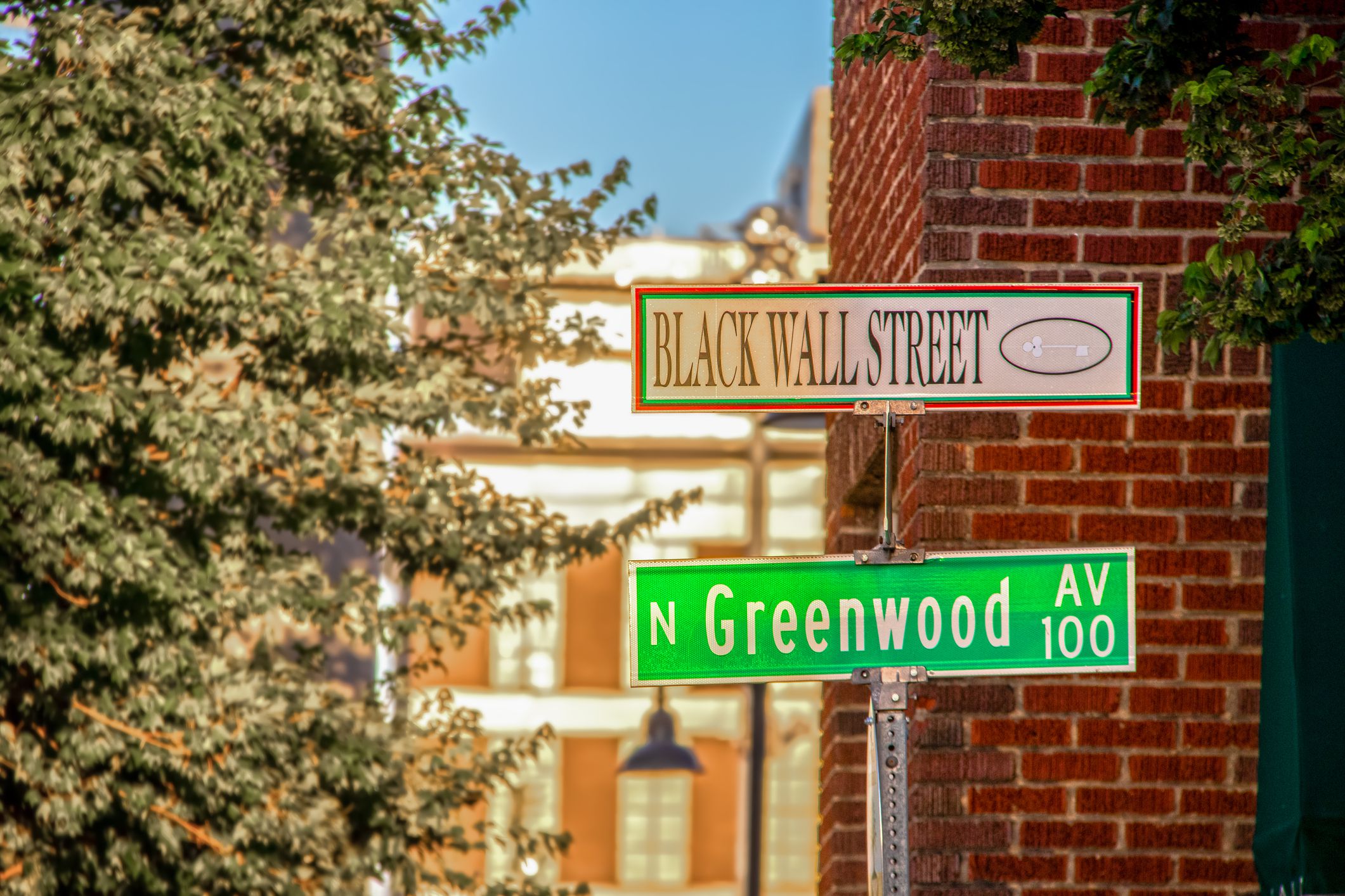 06_01_2020 Tulsa USA Black Wall Street and N Greenwood Avenue street signs - closeup - in Tulsa Oklahoma with bokeh background