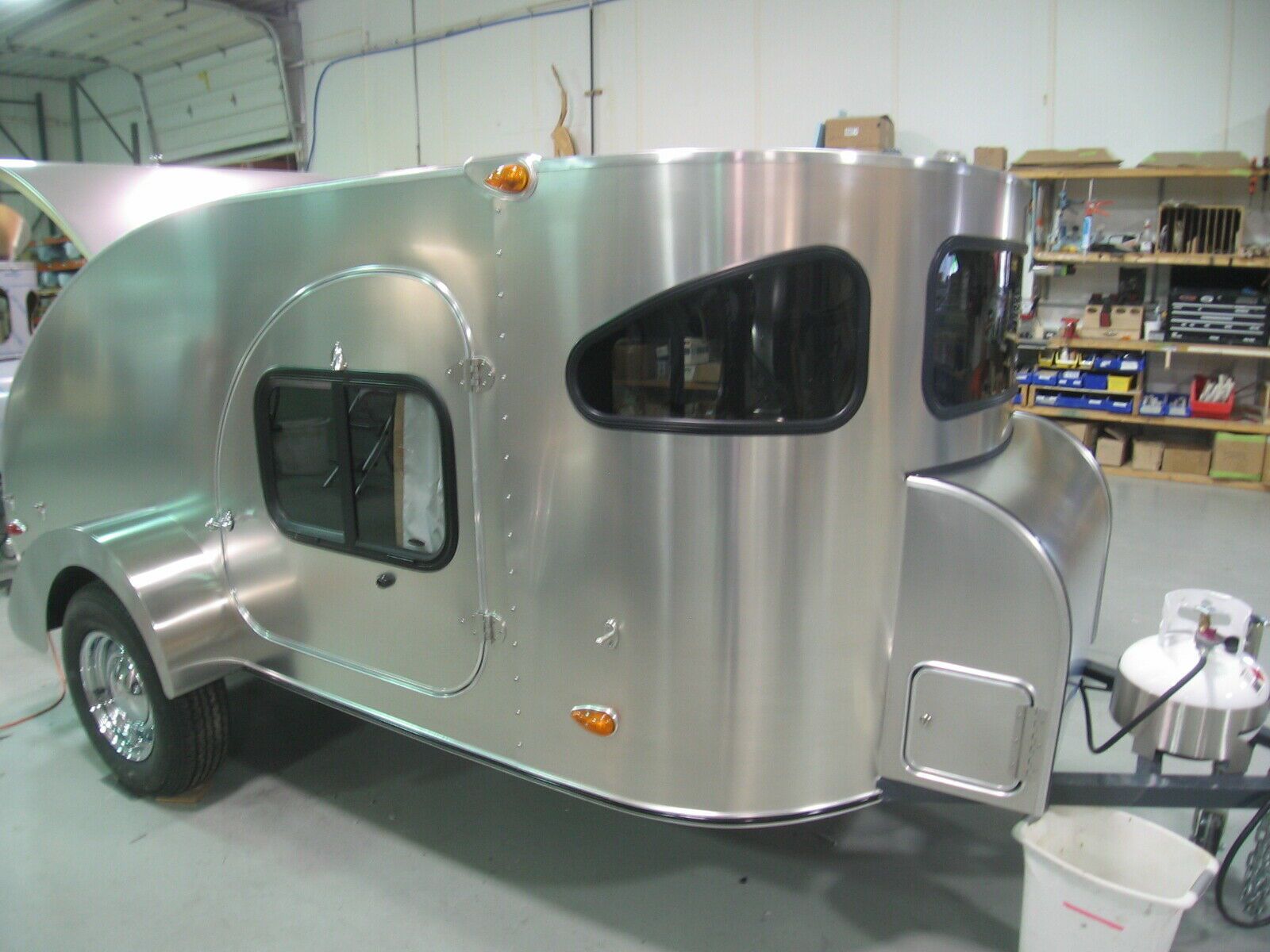 Silver raindrop trailer with black windows parked indoor.
