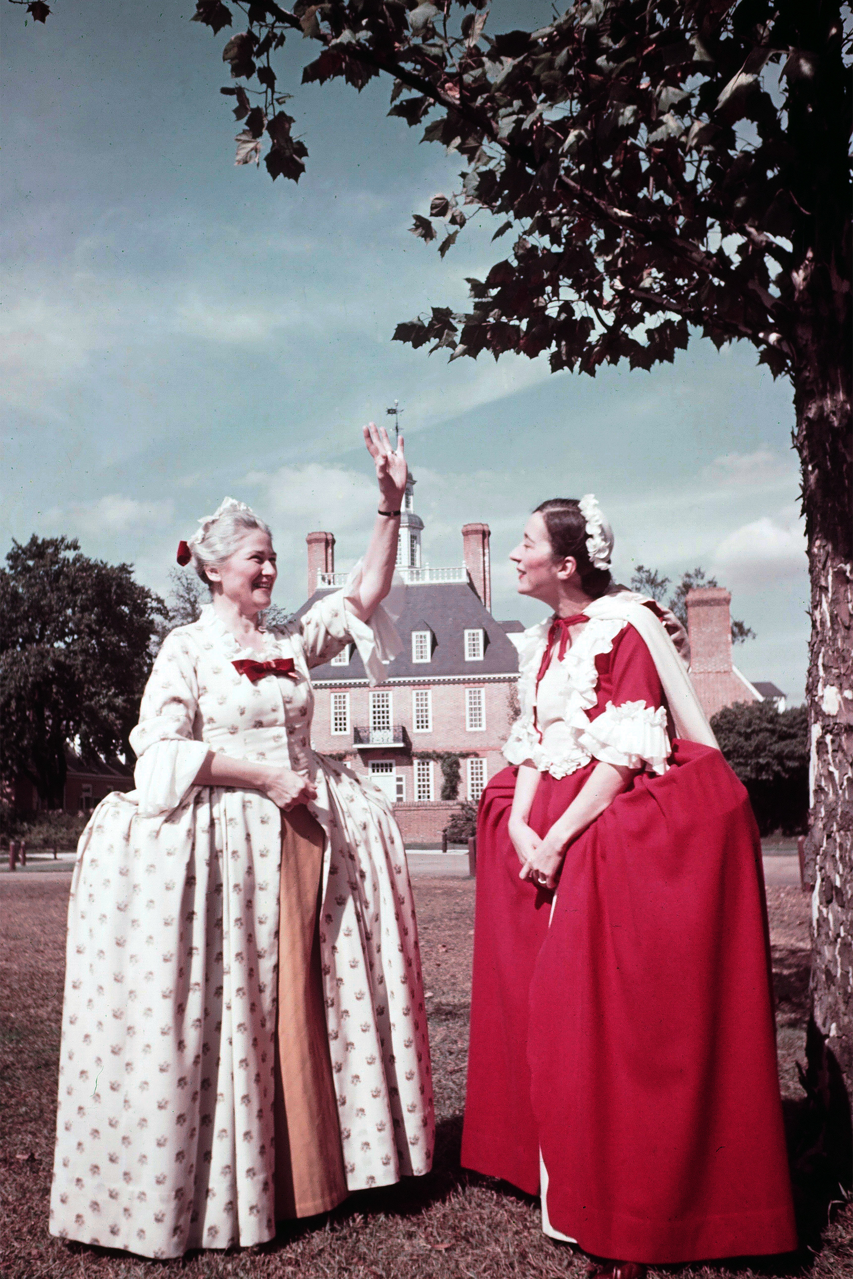 Two women dressed in Colonial dresses, reenact daily life in Colonial Williamsburg, Virginia