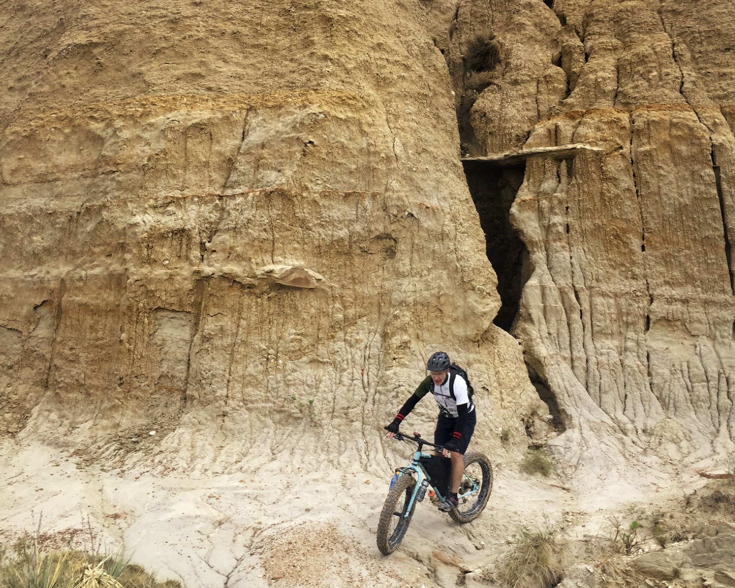 senior man mountain biking around a corner on the Maah Daah Hey trail in North Dakota