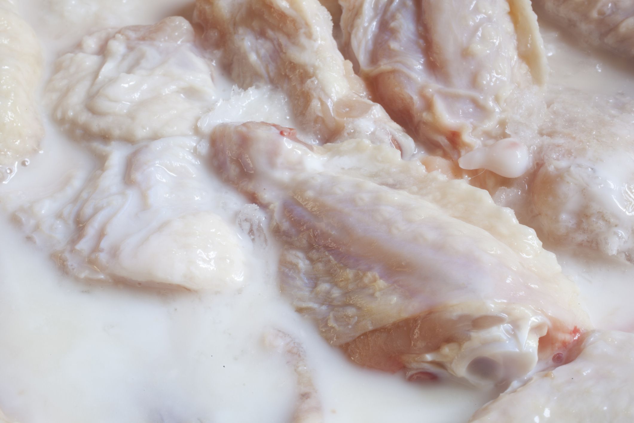raw chicken marinating in buttermilk