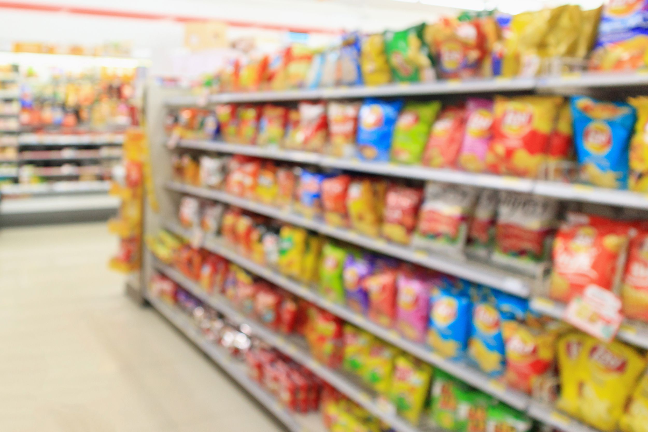 grocery store shelves with Potato chips snack blur abstract