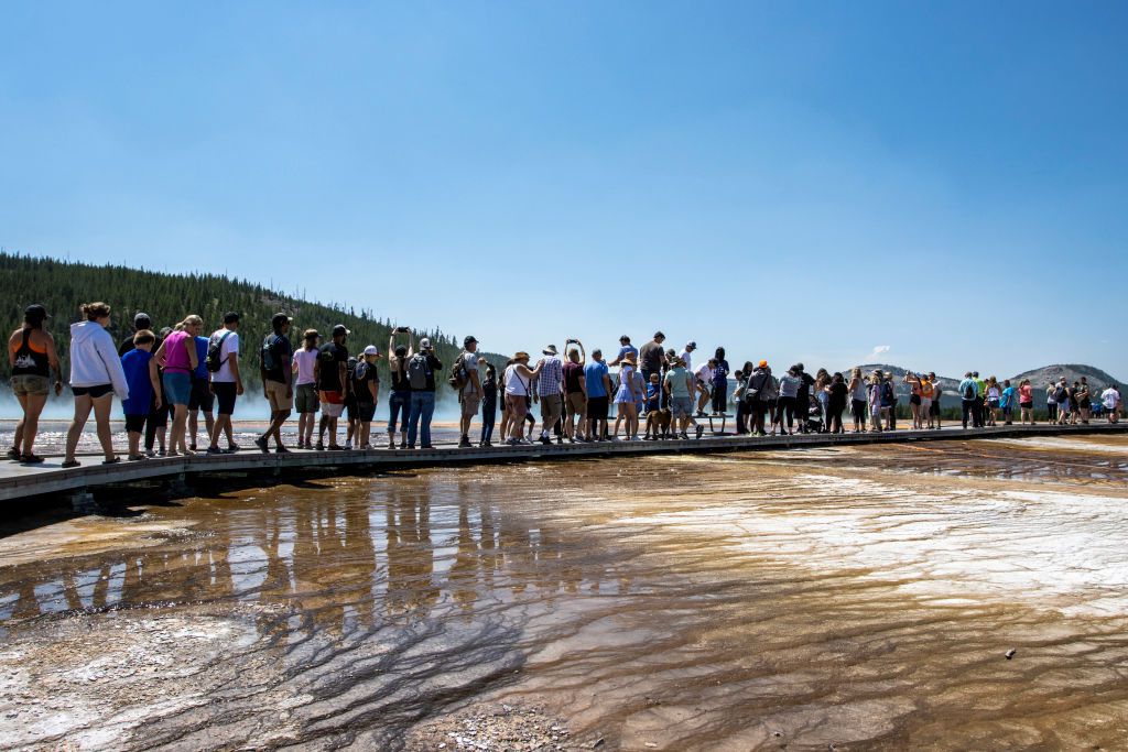 Tourists crowd in to the Midway Geyser Basin July 14, 2021 at Yellowstone National Park, Wyoming. Yellowstone is one of many national parks seeing record numbers of visitors this summer, leading to long lines and traffic jams.