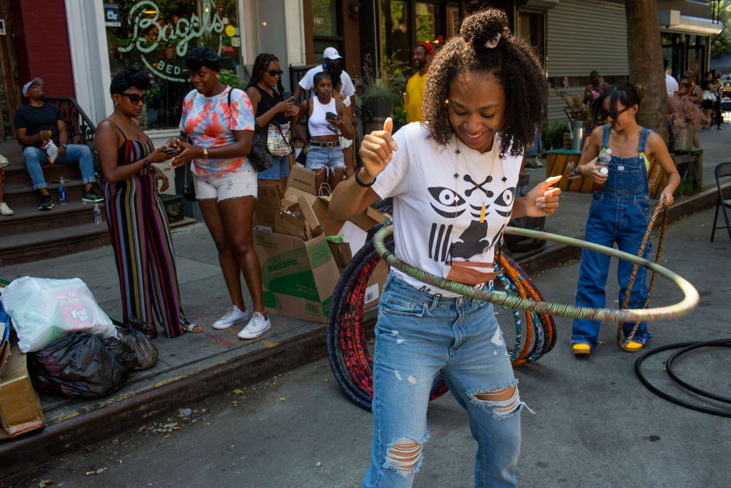 People practice with hula hoops at a block party on June 20, 2021 in the Bedford-Stuyvesant neighborhood of Brooklyn, New York. With vaccination levels high and a low infection rate of the COVID-19 virus, New York City is experiencing an emotional renaiss