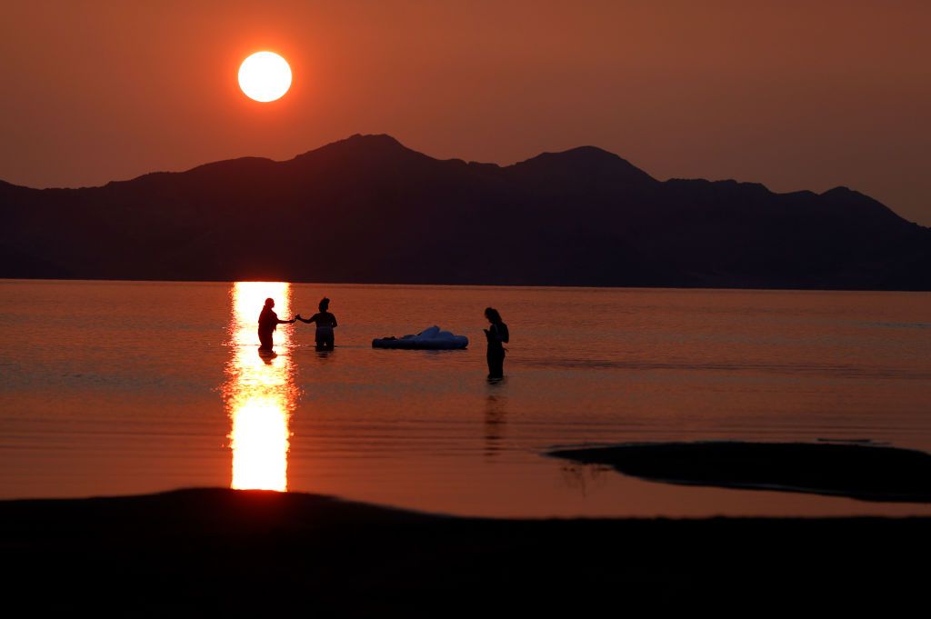 People wade in the waters of the Great Salt Lake on August 02, 2021 near Magna, Utah.