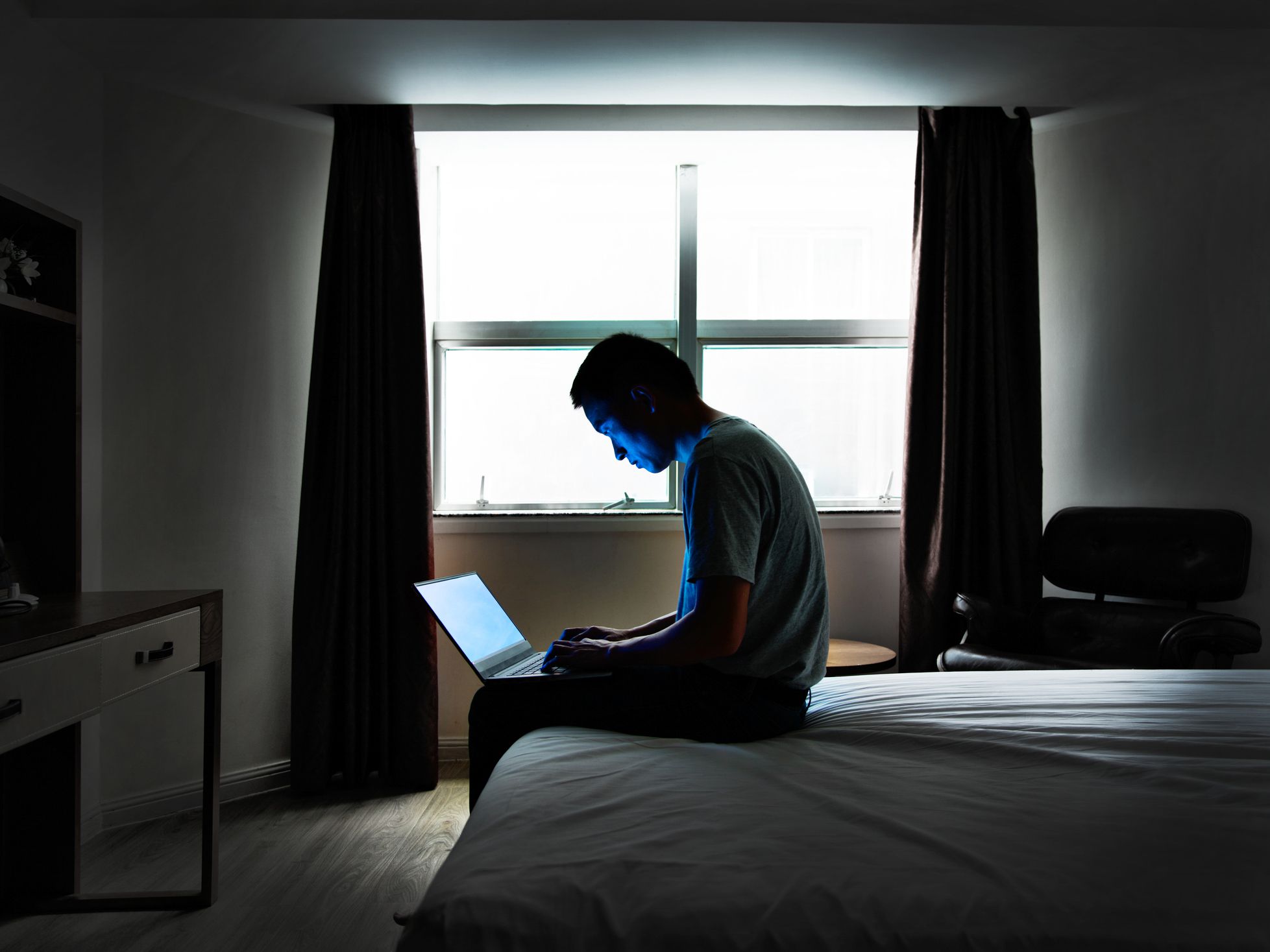 Man sitting in bed with a laptop