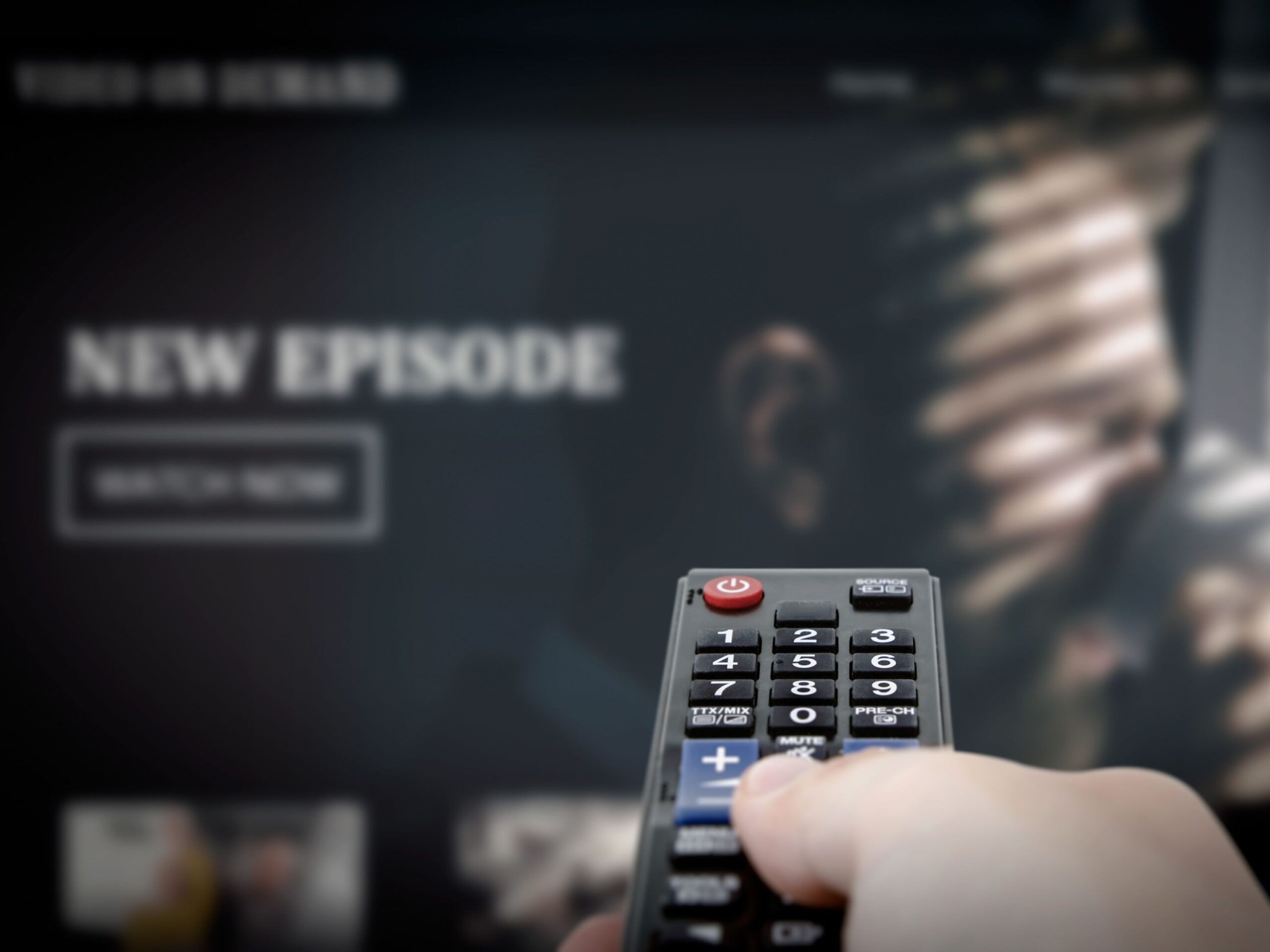 VOD service on television. Man watching TV, streaming service, video on demand, remote control in hand.