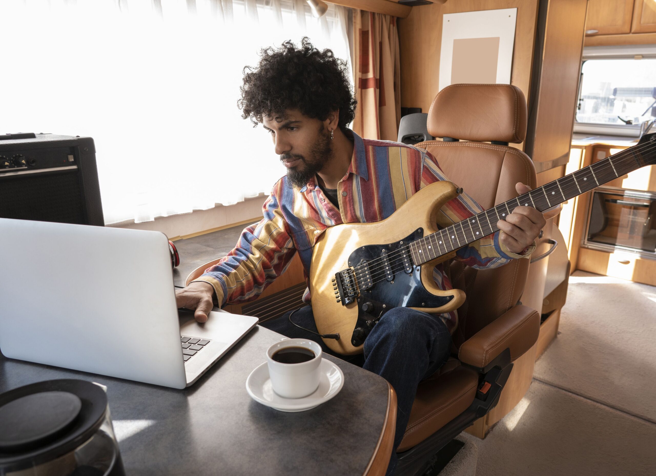man playing guitar in his RV