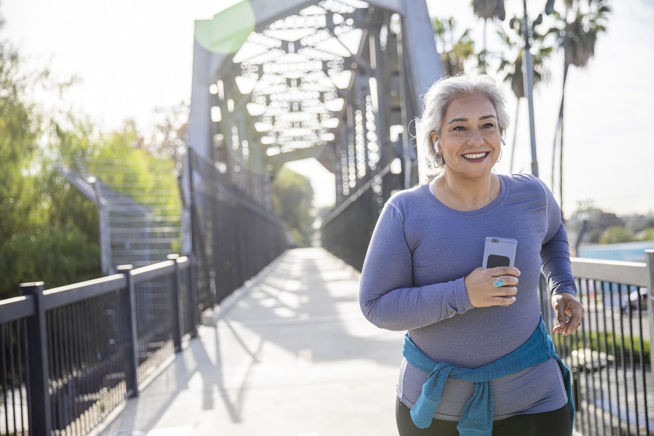 A mature Mexican woman jogging on a trail